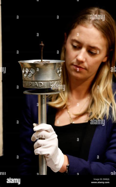 A Christies Employee Poses With The 1948 London Olympic Torch In London Britain 08 March 2012