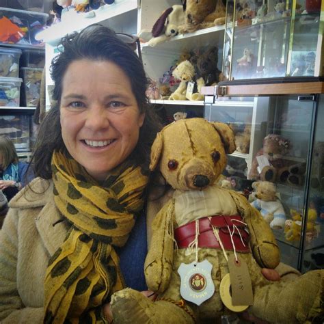 A Woman Holding Two Teddy Bears In Her Arms And Smiling At The Camera