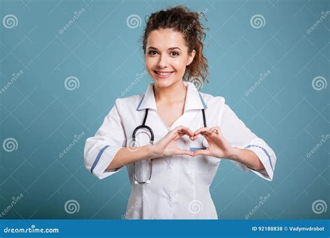 Woman Doctor With Stethoscope Showing Heart Sign Isolated On Blue Stock