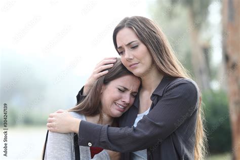 Sad Woman Crying And A Friend Comforting Her Stock Photo Adobe Stock