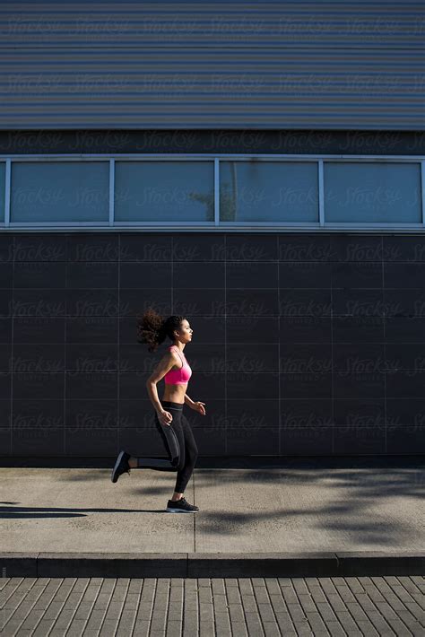 Fit Woman Running Outdoors By Stocksy Contributor Michela Ravasio Stocksy