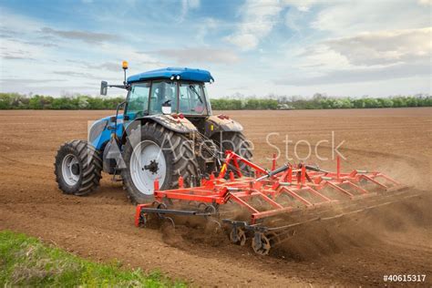 Fotobehang Small Scale Farming With Tractor And Plow In Field Nikkel