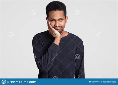 Black Sad Young Man Looks With Dejected Expression Holds Chin Has