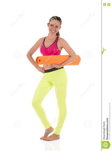 smiling brunette woman in sports neon yellow leggings and pink bra standing with the orange