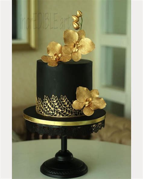 Wedding cake is covered in fondant icing designed with hand black piping cake. Black cake with gold accents and gold hand crafted orchids ...