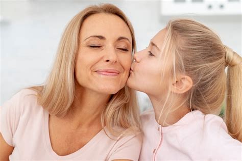 Free Photo Adorable Daughter Kisses Her Mother On Cheek