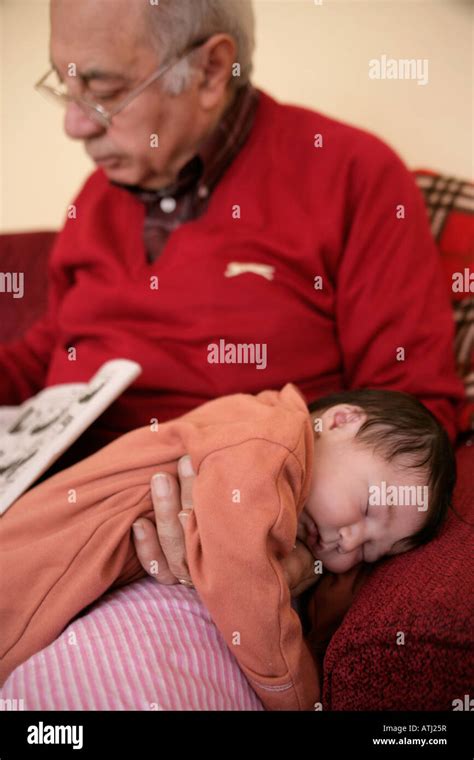 Una Semana De Nacido El Bebé Duerme En El Regazo De Tu Abuelo Mientras él Lee El Periódico