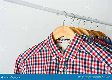 Long Sleeve Red And Blue Checkered Shirt On Wooden Hanger Over White