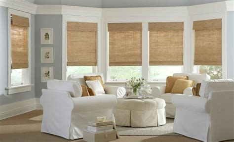 A Living Room Filled With White Furniture And Windows Covered In Shades