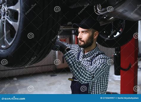 Auto Mechanic Working Underneath A Lifted Car Stock Image Image Of