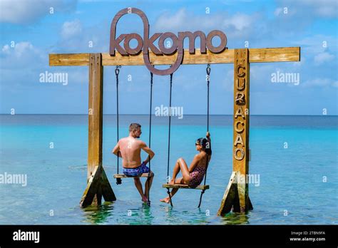Couple at a swing in the ocean of Curacao Caribbean Island Kokomo Beach