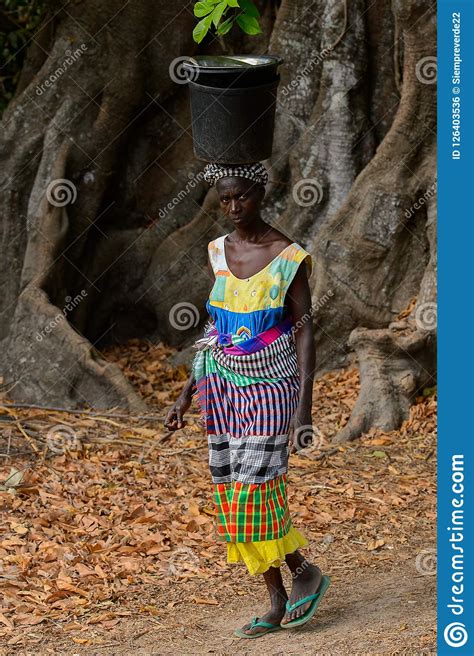 unidentified local woman carries a bucket on her head in a vill editorial photo image of race
