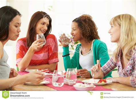 Group Of Women Sitting Around Table Eating Dessert Stock