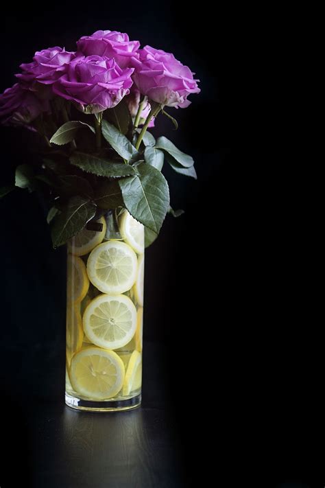 A Vase Filled With Lemon Slices And Purple Flowers
