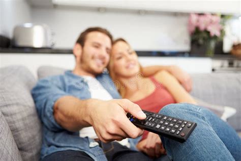 Young Couple Sitting On Sofa Watching Television Stock Photo Image Of