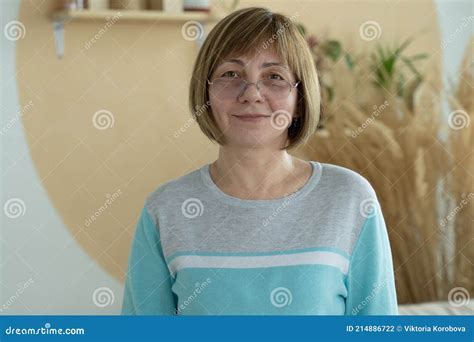 smiling middle aged mature woman looking at camera having confident happy facial expression
