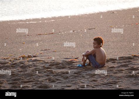 Young Minority Boy Sitting Alone On Beach Hi Res Stock Photography And