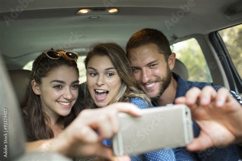 A Group Of People Inside A Car Two Women And A Man Taking A Selfie Kaufen Sie Dieses Foto