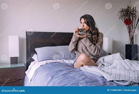 Latin Woman Lying In Her Bedroom Having A Cup Of Coffee Quarter Stock