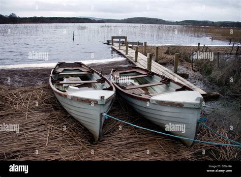 Two Rowing Boats Tied Up By Lake Shore Stock Photo Alamy