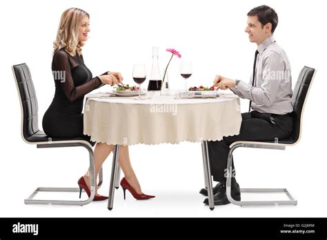 Young Man And Woman Eating On A Date Seated At A Restaurant Table Stock