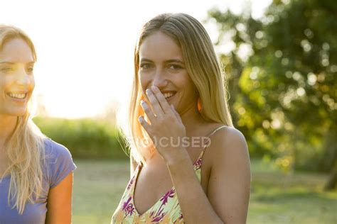Two Women Laughing Together Outdoors Day Cropped Stock Photo