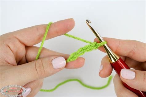 Two Hands Crocheting The End Of A Piece Of Green Yarn