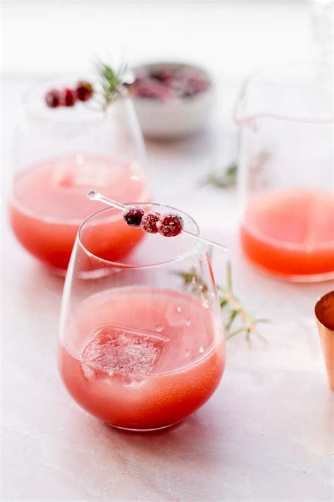 refreshing cranberry paloma cocktails for the holidays garnished with sugared cranberries and