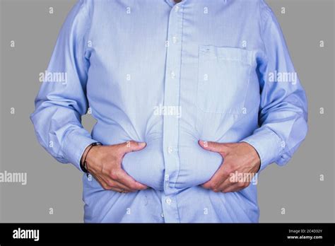 Man With Overweight And A Big Belly Wearing A Shirt Holding His