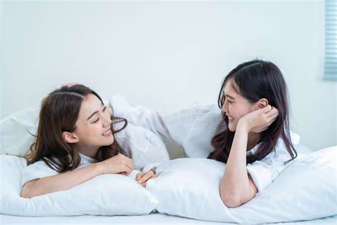 asian beautiful lesbian couple lying on bed and looking at each other attractive romantic girl