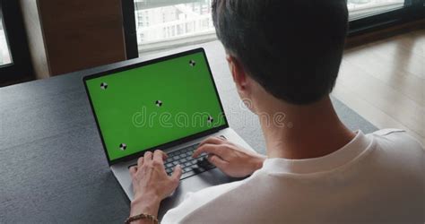 Over The Shoulder Shot Man Using Laptop Computer With Green Screen