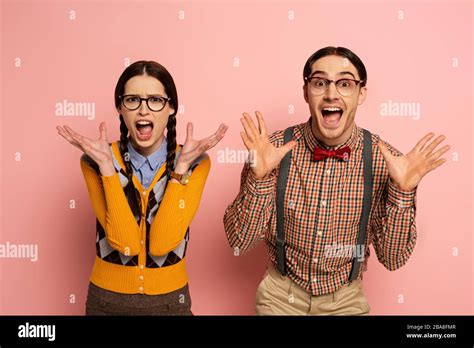 Couple Of Shocked Nerds In Eyeglasses Yelling On Pink Stock Photo Alamy