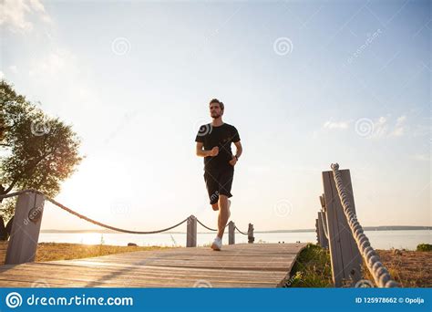 Full Length Shot Of Healthy Young Man Running On The Promenade Male