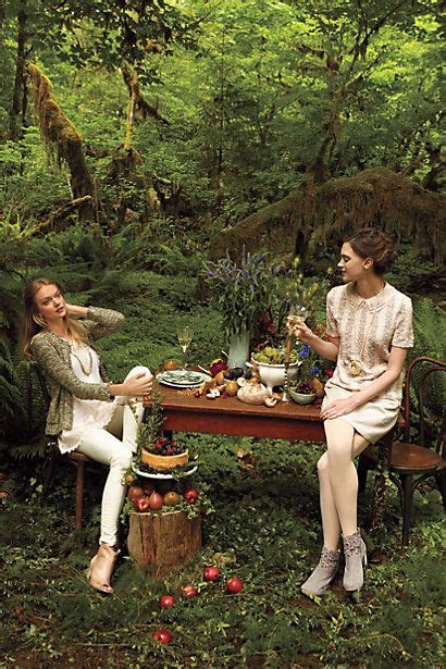 Two Women Sitting At A Table In The Woods Eating Food And Talking To