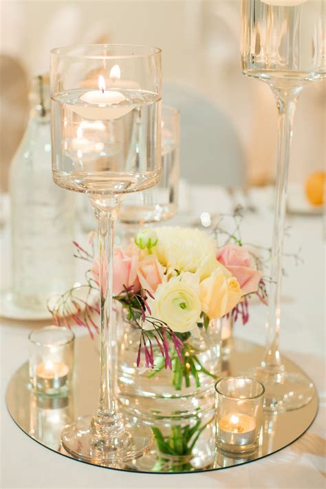 Floating candle centerpiece on a round mirror base with fresh flowers #