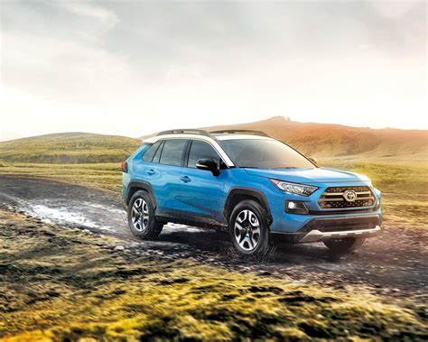 2020 Toyota Rav4 Trail In Blue With White Roof Driving Through A Muddy