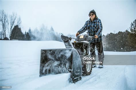 Snowy Winter Man Using A Snowblower Outdoors Stock Photo Download