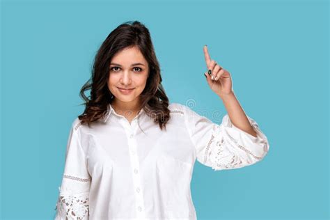 Pretty Brunette Girl Pointing Something By Finger Isolated Over The Blue Background Zdjęcie
