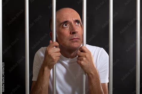 Desperate And Sad Man Behind Bars Stock Photo Adobe Stock