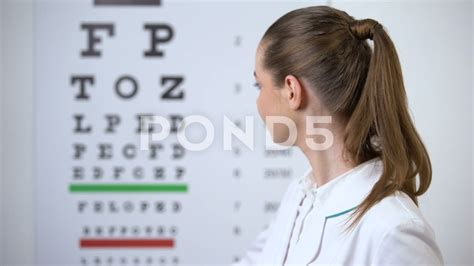 Female Optometrist Pointing At Eye Chart Vision Test In Ophthalmology