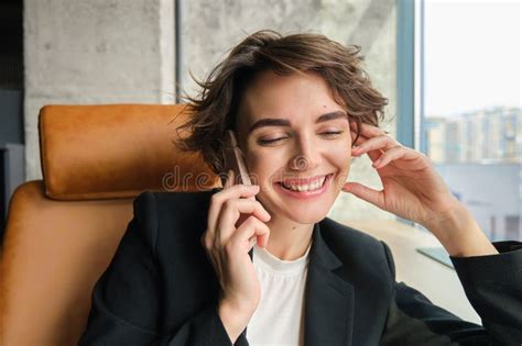 close up portrait of corporate woman laughing and smiling talking over the phone sitting in