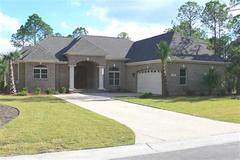 a house with palm trees in front of it and a driveway leading to the