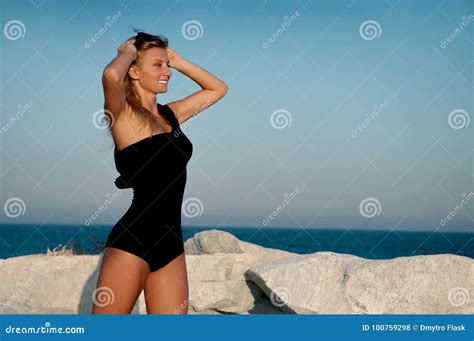 Schöne Gebräunte Frau Im Schwarzen Badeanzug Auf Dem Strand Stockfoto Bild Von Felsen Haut