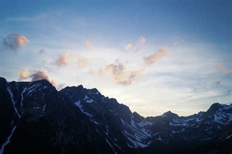 Black Mountain With White Snow Under Blue Sky · Free Stock Photo