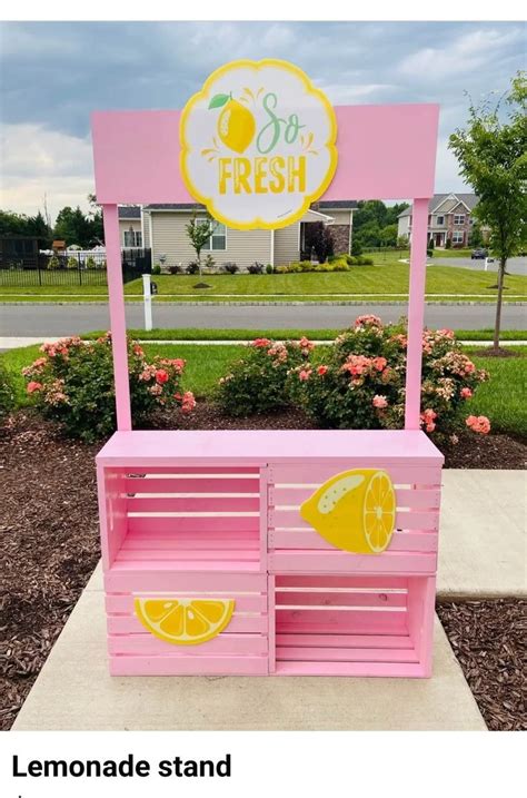 a pink lemonade stand sitting on top of a sidewalk