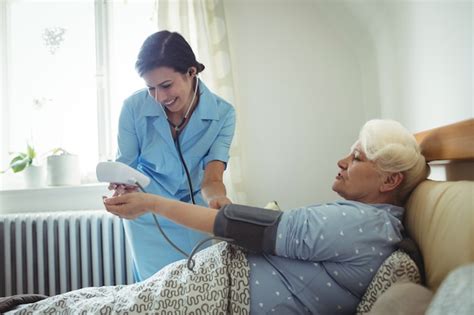 Premium Photo Nurse Checking Blood Pressure Of Senior Woman