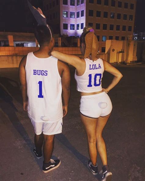 two people in basketball uniforms standing next to each other with their hands on their hipss