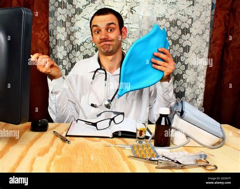 Doctor Proctologist Is Wearing White Medicine Uniform And Holding Blue Enema In Hands Stock