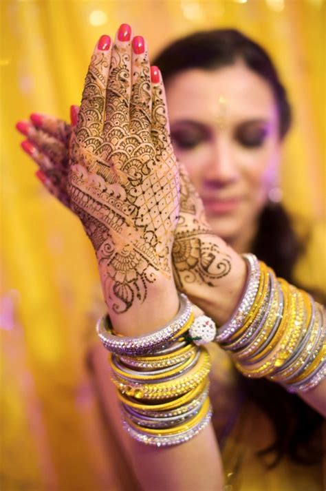 A Woman Holding Her Hands Up With Henna On It