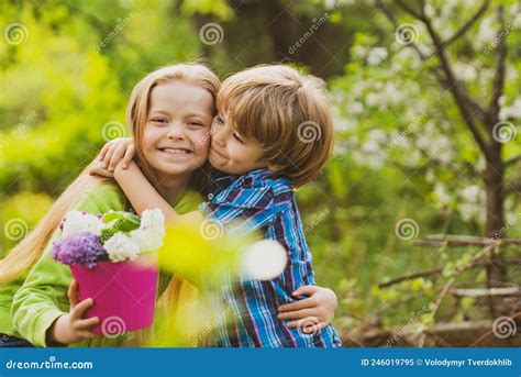 Little Boy And Girl In Love In Garden Cheerful Kids Playing On Park